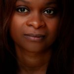 A compelling close-up portrait of a woman with an intense gaze, emphasizing natural beauty.